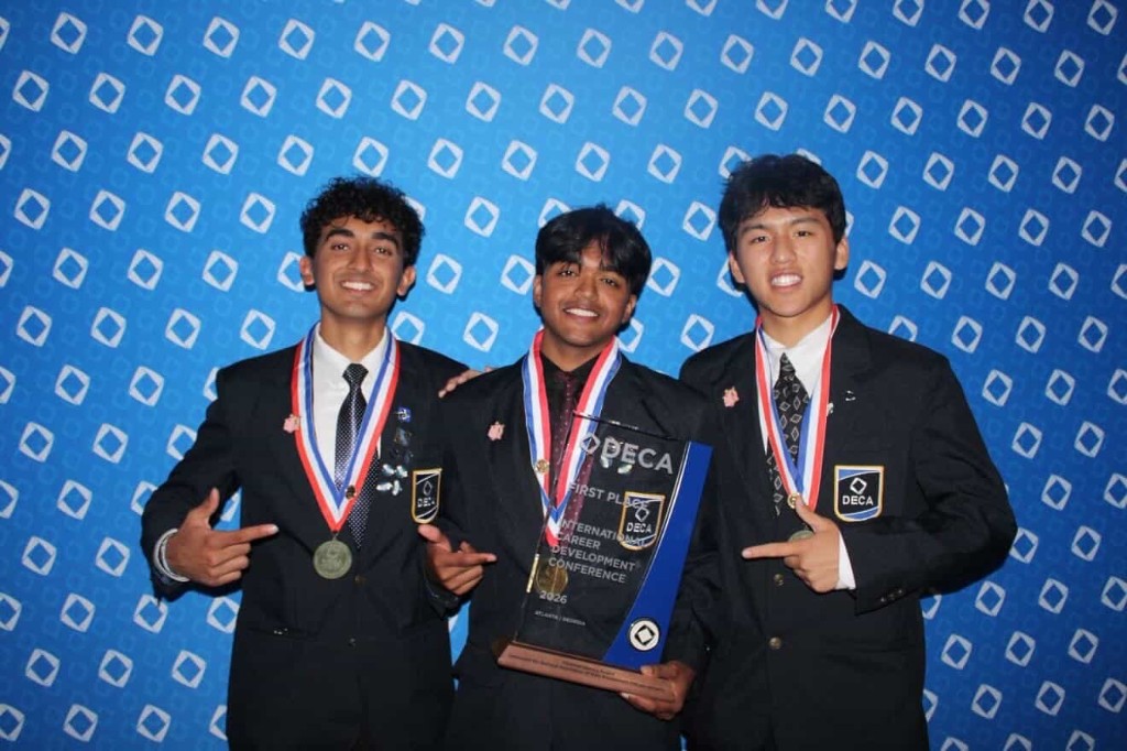 Three students holding a first-place DECA ICDC award