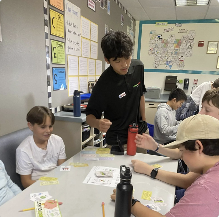 A MoneyMind facilitator guiding students through a round of InvestQuest