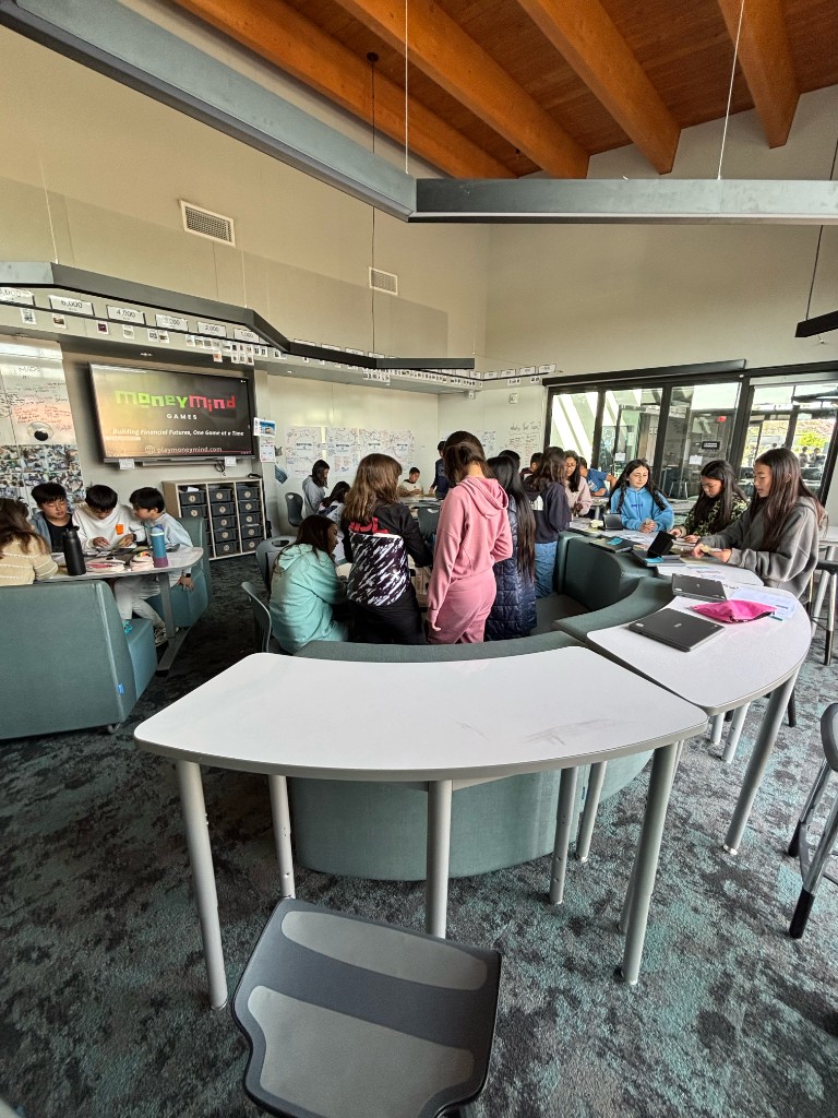 A classroom showcase with several groups playing InvestQuest