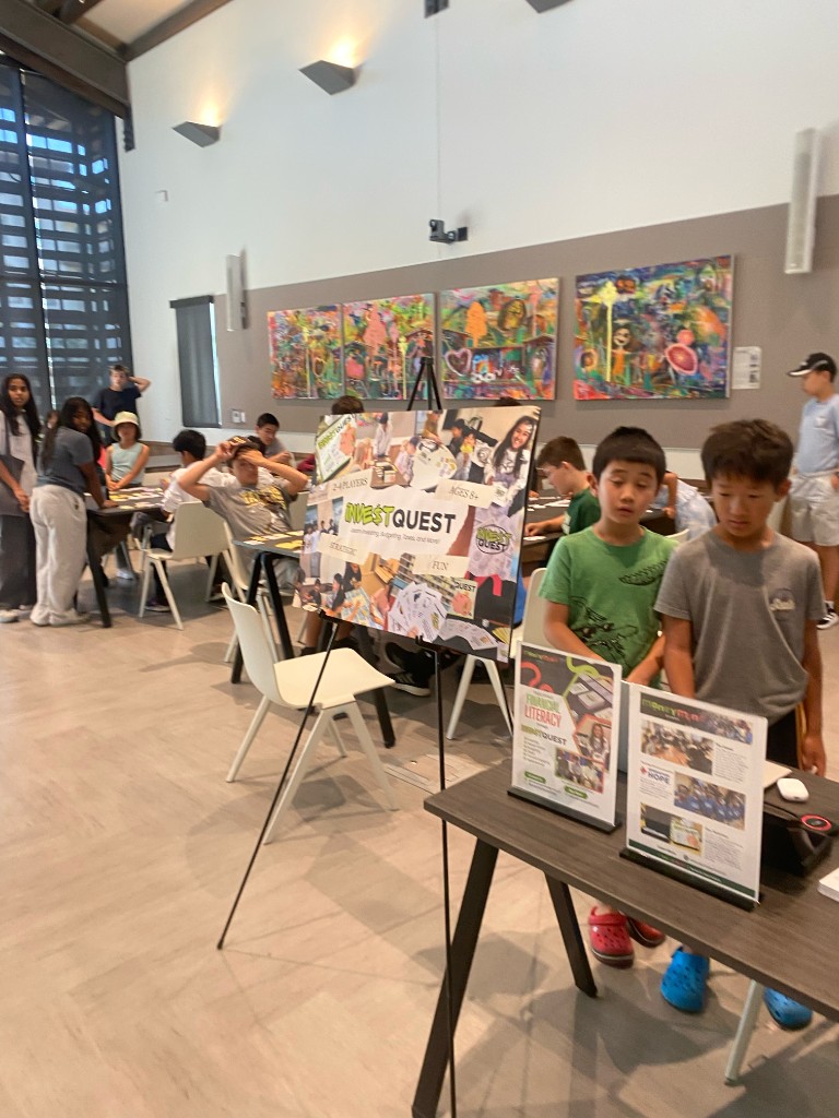 Kids beside an InvestQuest display at a library event