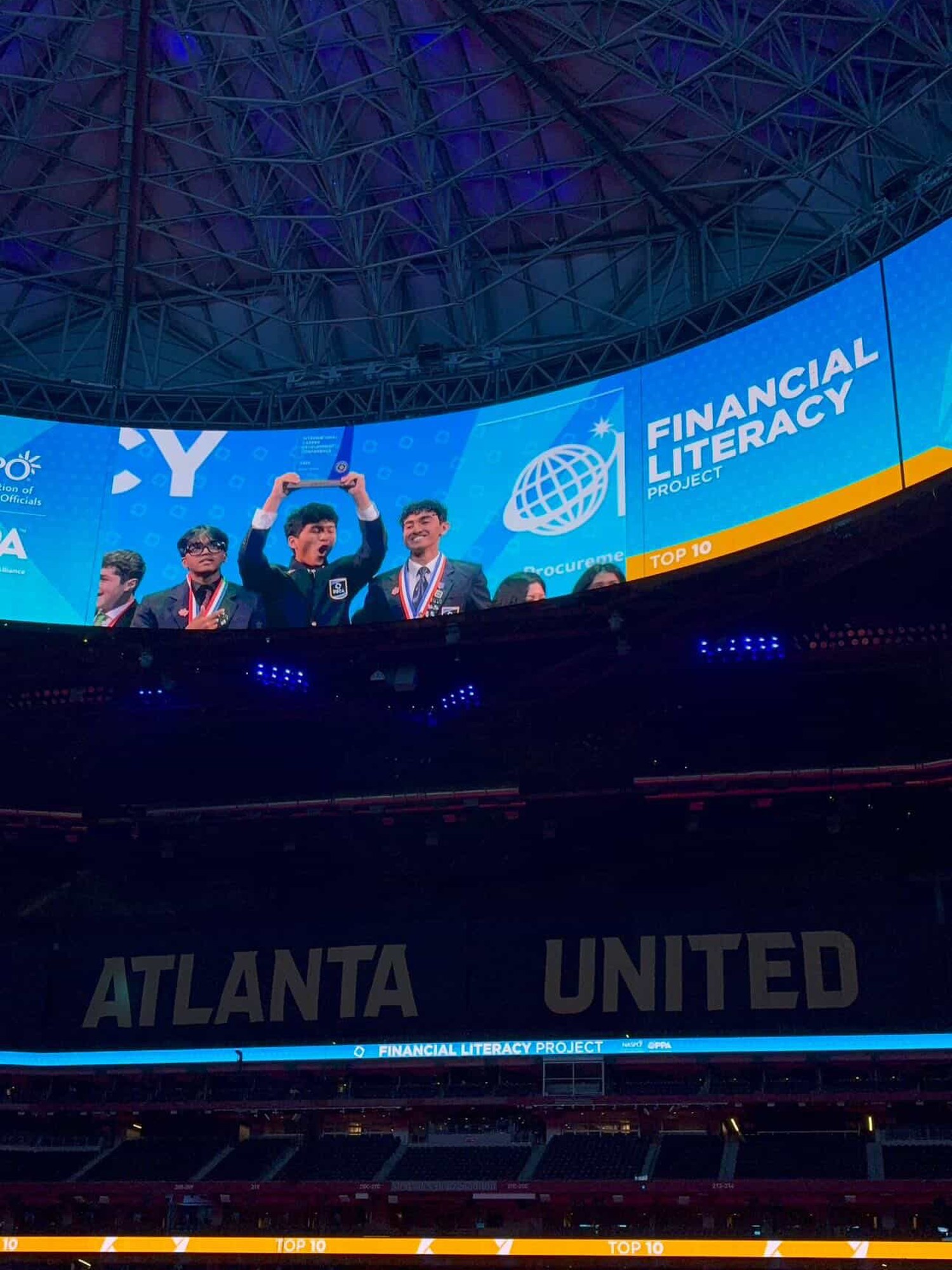 The MoneyMind Games team on stage after winning DECA ICDC